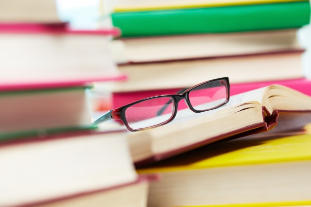 close-up-image-of-eyeglasses-among-piles-of-books-SBI-300730216.jpg